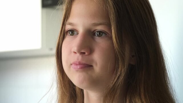 Close up of teenage girl taking pill and drinking water from glass at home. Concept of healthcare and medication
