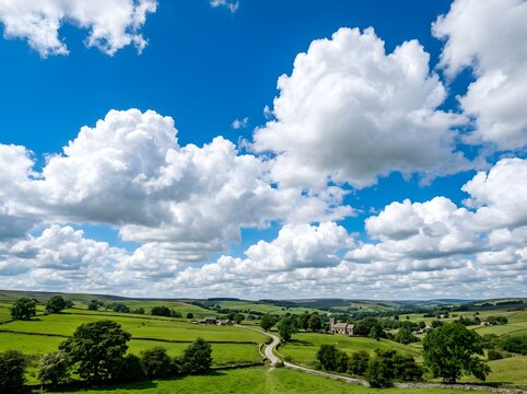Rolling green hills with white clouds and blue sky