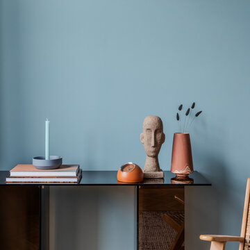 Modern Interior Decor with Artwork, Candle, and Books on a Console Table in a Serene Blue Room