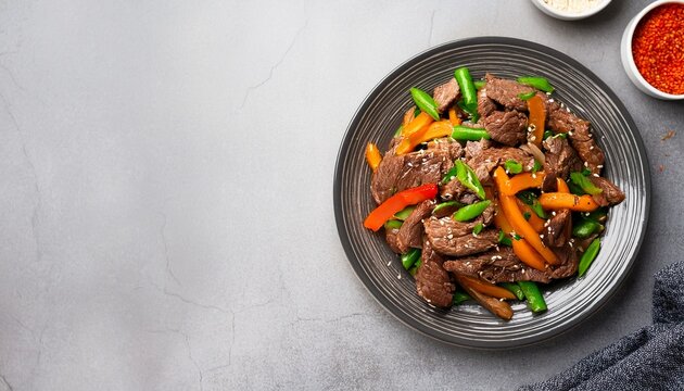beef stir fry in a plate top view asian meat with vegetables on a grey background copy space for text