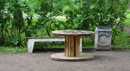 An improvised wooden table made from an empty wooden cable reel stands in the recreation area © Станислав Вершинин