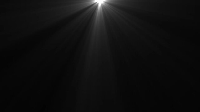  Glowing white light rays and sunbeams shining down from the top on black background