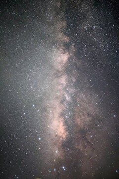 breathtaking view of the Milky Way galaxy stretching across a dramatic starry night sky, set against a dark natural horizon. Perfect for concepts of stargazing, outdoor adventure, and cosmic mystery.