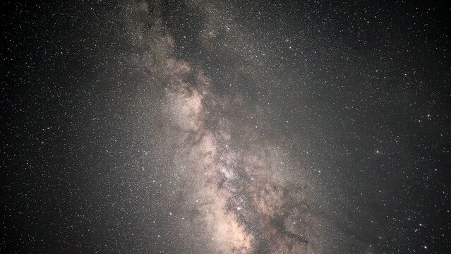 Stunning astrophotography capturing the glowing core of the Milky Way galaxy in a dark, clear night sky above a peaceful natural landscape. Ideal for themes of space exploration, astronomy, nocturnal 