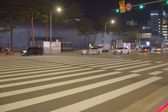 Vibrant Seoul Night Intersection with Streaking Car Lights and Pedestrian Crosswalk