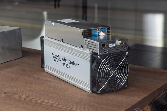Amsterdam, Netherlands, May 23, 2026. A professional Whatsminer M30S++ ASIC cryptocurrency mining hardware unit resting on a wooden surface inside a shop.