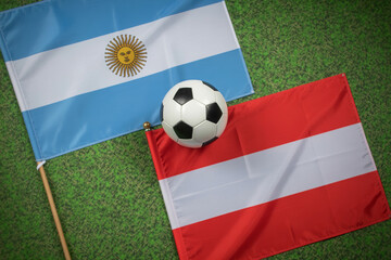 Fototapeta premium soccer ball between argentina and austria flags on grass photo football flag field sports competition international team spirit image realistic outdoor event
