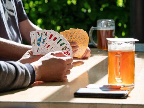 Kartenspielen im Biergarten - Schafkopf mit deutschem Blatt - traditionelles Stammtisch-Vergn&uuml;gen