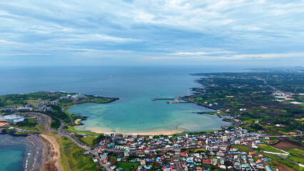 Aerial drone view of Seongsan Ilchulbong coastal village farmland and ocean landscape in Jeju Island South Korea © 은수 조