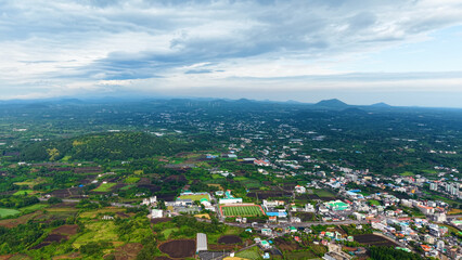 Obraz premium Aerial drone view of Seongsan Ilchulbong coastal village farmland and ocean landscape in Jeju Island South Korea