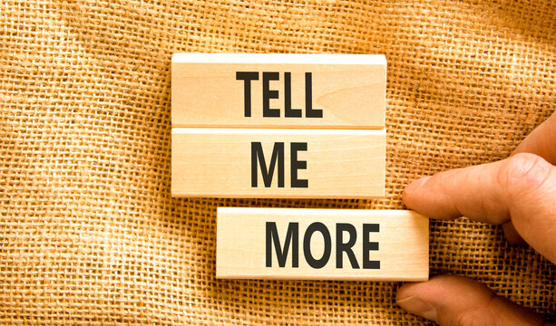 Tell me more words symbol. Concept words Tell me more on beautiful wooden blocks. Beautiful canvas background. Businessman hand. Business and tell me more concept. Copy space.