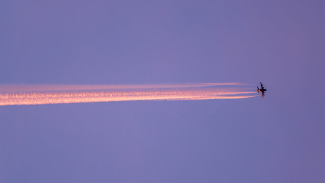 Passing  aircraft with colourful vapour trail