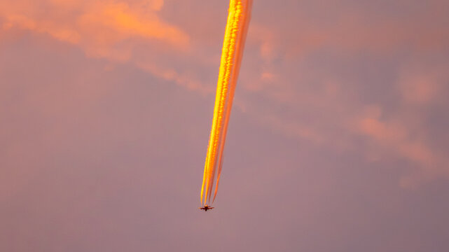 Passing  aircraft with colourful vapour trail