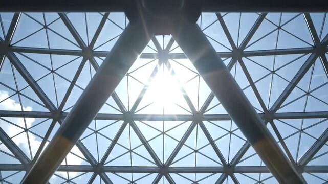 Geometric glass roof structure with sunlight.