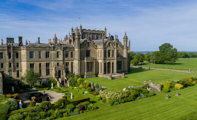 Fototapeta premium Allerton Castle, North Yorkshire, England aerial view of the historic Gothic revival stately home and luxury wedding venue surrounded by gardens, woodland and Yorkshire countryside.