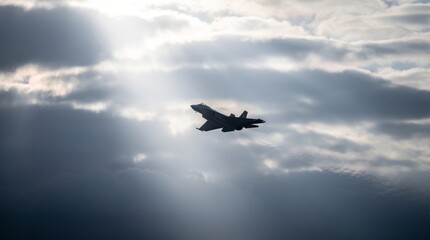Fototapeta na wymiar Silhouette of a fighter jet climbing through dramatic clouds