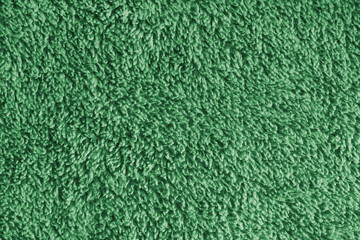 Close up, macro green microfiber bath towel texture, soft fluffy terry cloth surface, absorbent fabric details. Cozy textile material background for bathroom, cleaning or spa concepts © katyamaximenko