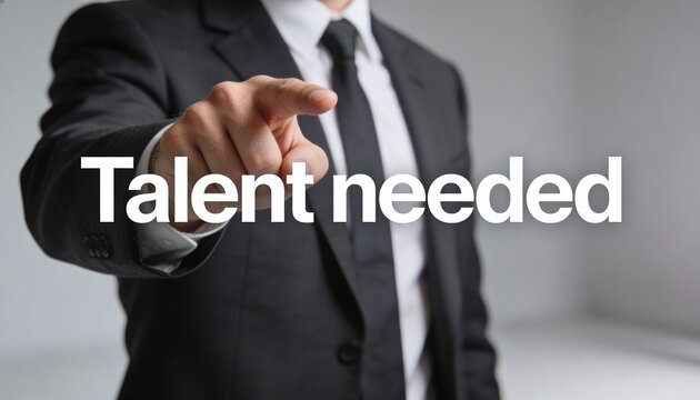 Professional man in a suit points directly forward, an assertive gesture, with the words "Talent needed" overlaid digitally, conveying a clear message of recruitment and opportunity