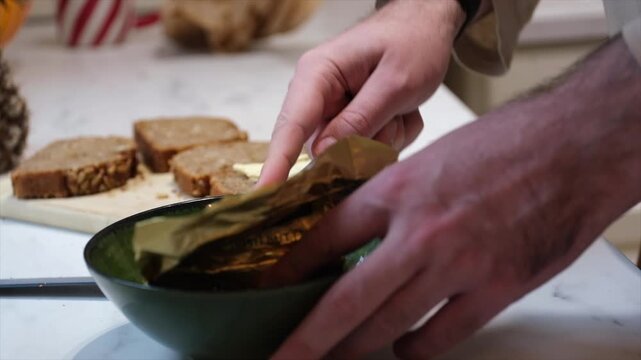 Man Spreading Butter on Bread During Homemade Breakfast Preparation
