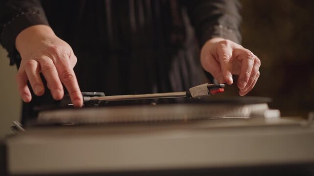 Closeup hands cueing tonearm on turntable, gentle adjustment of stylus over record, precise movement under soft warm light, focused listening ritual by audiophile, anticipation before first note.