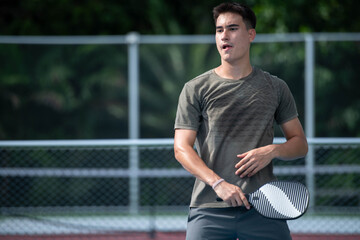 Naklejka premium Young male athletes playing pickleball and practicing for competition on an outdoor field