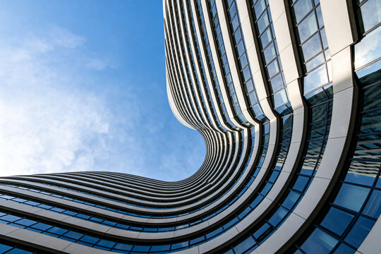 Modern Curved Glass Office Building with Blue Sky Background