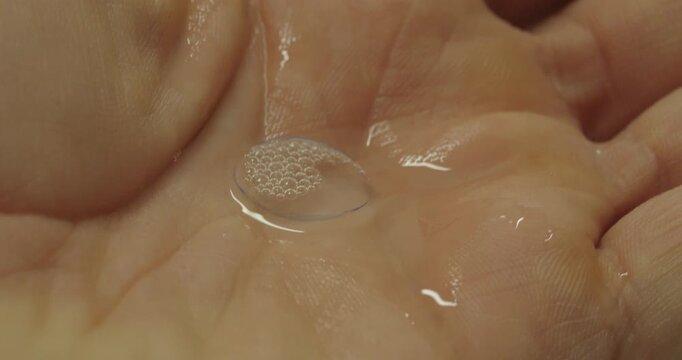 Macro Close Up of Contact Lens Being Rinsed and Cleaned by Hand