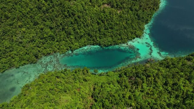 Breathtaking high angle panorama of untouched Banggai shorelines &ndash; Vivid turquoise water gradients, sandy bays and rugged cliffs in Sulawesi, clean cinematic background asset for advertising
