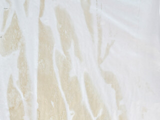 Naklejka premium crumpled white paper on brown wooden background.
