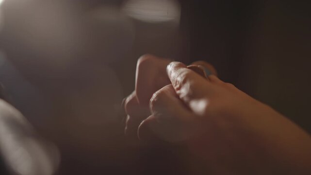 Expert sewing craftsmanship. Skilled stitching in soft lighting. Careful fabric mending with delicate needle techniques. Precise textile restoration executed thoughtfully under gentle illumination