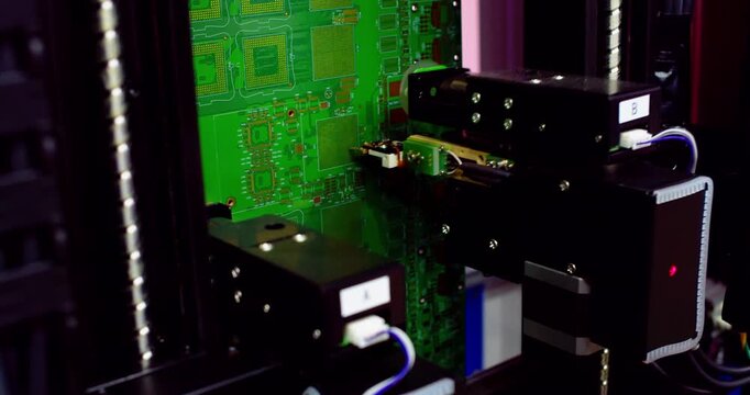Automated industrial robot tester inspects microchips and components on a motherboard. Closeup of advanced technology, equipment, and digital hardware quality assessment.