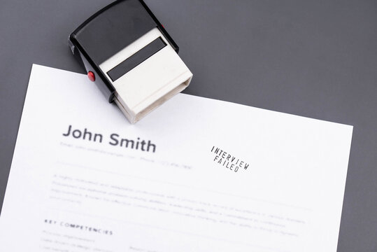 Fake mock CV (curriculum vitae) rejected by HR with Job Interview Failed stamp. Concept of job search, recruitment process, rejection, downsizing, restructuring, and job loss.