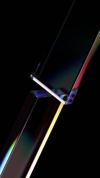 Abstract iridescent glass shapes on a black background, vertical 4k seamless loop 3d animation