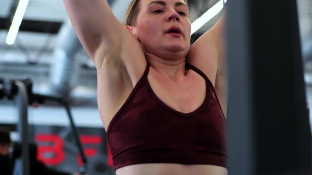 Athletic Woman Using Lat Pulldown Machine At Gym