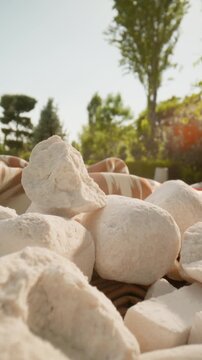 Close-up of traditional kurt, dried fermented cheese snacks, arranged outdoors under natural sunlight. Authentic Central Asian dairy product, local cuisine, cultural heritage, artisanal production