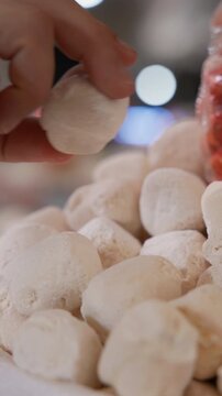 Close-up of a hand selecting traditional kurt at a local Uzbek bazaar. Kurt is a dried fermented dairy snack widely enjoyed across Central Asia. Authentic shopping moment, traditional food culture