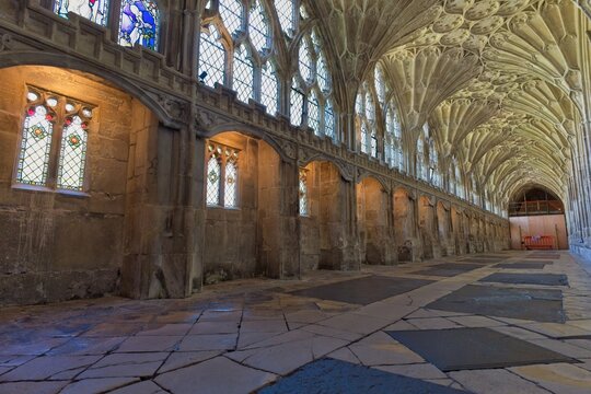 A grand vaulted hall with a high, intricately ribbed ceiling and large stained-glass windows at Gloucester Cathedral - Gloucester - Gloucestershire - UK