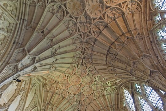 An ornate stone vaulted ceiling with intricate fan-like ribs and decorative circular patterns at Gloucester Cathedral - Gloucester - Gloucestershire - UK