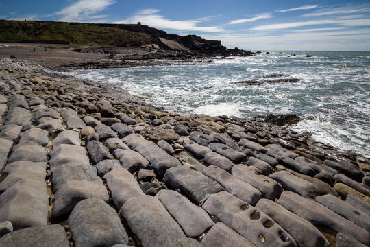 Geological rock strata formations on the beach at Bude under a blue sky