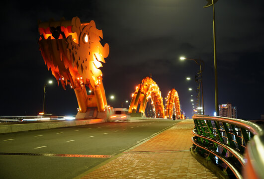 Golden dragon bridge lit up at night over Han River in Da Nang Vietnam