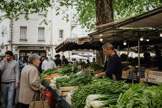 March&eacute; en ville, stand de fruits et l&eacute;gumes avec un maraicher et une cliente &acirc;g&eacute;e