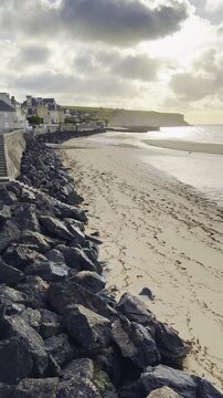 Vertical video shows coastal landscape of quaint French town Arromanches