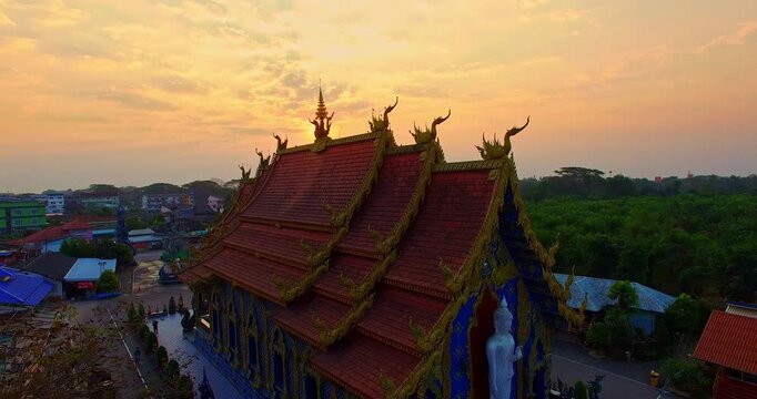 Aerial View The magnificent blue stupa and richly decorated temple structures showcase exquisite Thai craftsmanship and Buddhist artistry at Wat Rong Suea Ten. Ornate Blue Church and Stupa at Sunrise