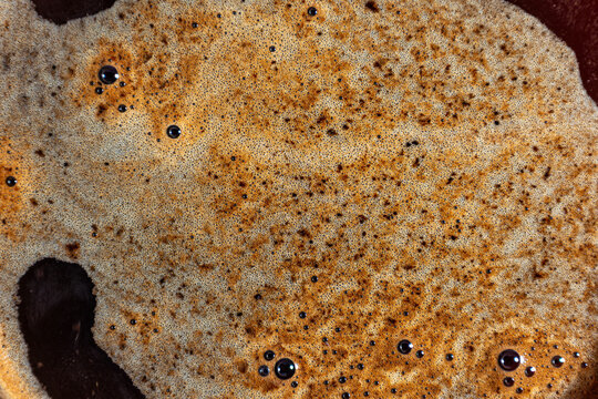 Fresh espresso crema surface texture with microfoam bubbles detail