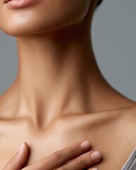 Naklejka premium Close-up of woman touching chest gently, wellness and self-care concept, soft beauty lighting