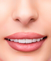 Obraz premium Detailed shot of smiling human lips showing bright white teeth