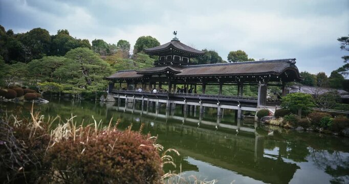 Old taihei-kaku bridge in still pond of Japanese village - wide shot