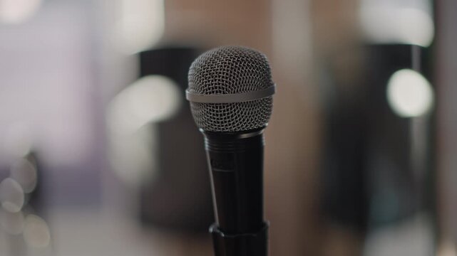 Close up microphone in classroom, music lesson setup with blurred desks and bokeh lights, teacher guidance implied, worn stand, focused practice vibe, youthful energy, rehearsal routine