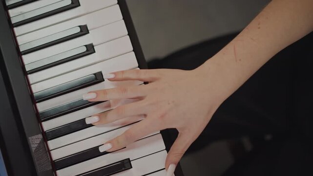 Female hands practicing piano fingering, overhead studio shot with digital keyboard, focused coach energy, precise technique and tempo work, rehearsal for performance or recording, polished nails