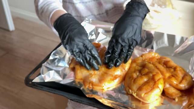 Chicken breast in curry marinade prepared for baking from seasoning and arranging on foil to homemade oven roasted meal